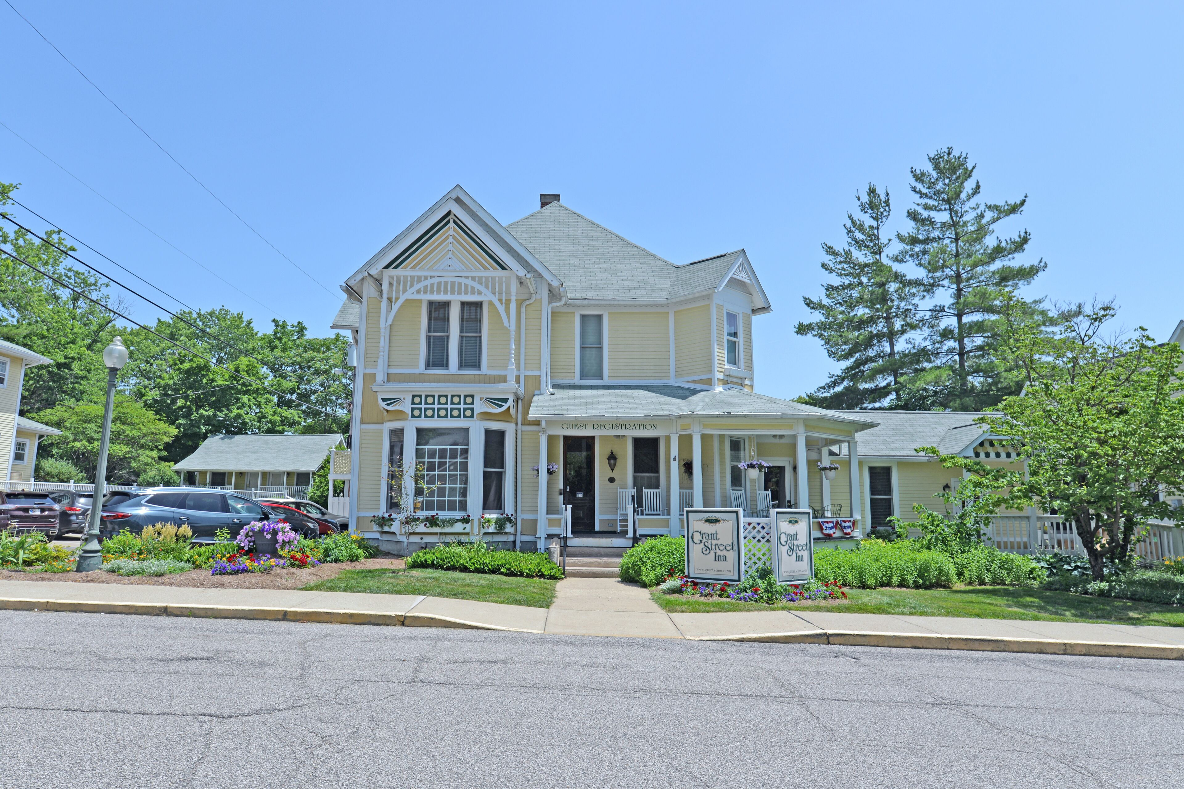 A two-story building with a porch and a sign that reads "Grant Street Inn."