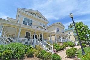 A two-story house with a porch, a staircase, and a well-maintained garden.