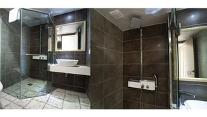 A modern bathroom with a glass shower enclosure, a white sink, and a large mirror.