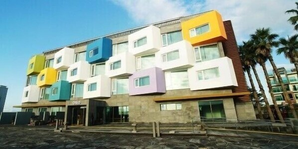 A multi-story building with a modern design, featuring a mix of white, yellow, blue, and purple facades.