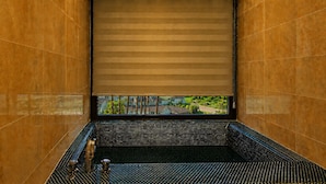 A bathroom with a large window, a shower area, and a view of a residential area. - Login Resort (Jeju City)