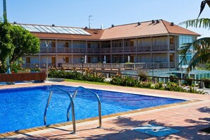 Una piscina cubierta, una piscina al aire libre de temporada, sombrillas