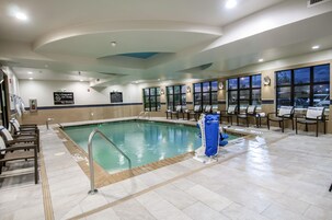 Una piscina con un puesto de salvavidas y un cartel de prohibido bucear.