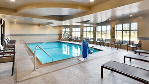 An indoor swimming pool with a diving board, lounge chairs, and a seating area with tables. - Hampton Inn & Suites Monroe (Monroe)