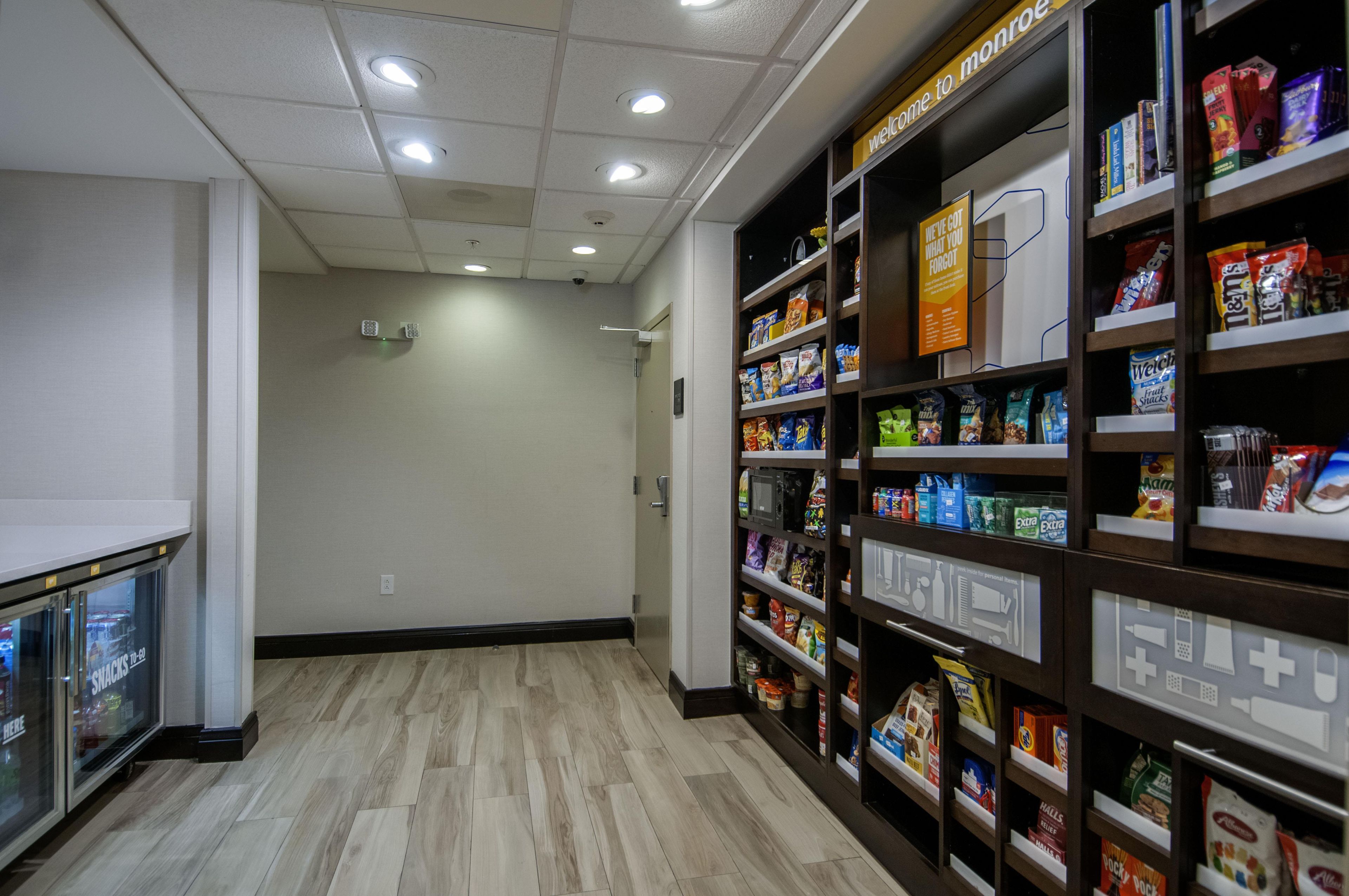 A snack bar with shelves stocked with various snacks and a sign indicating it's open.