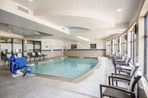 A swimming pool with lounge chairs and a no-lifeguard sign.