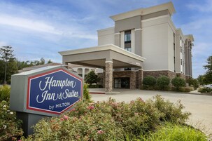A Hampton Inn & Suites by Hilton building with a clear sky.