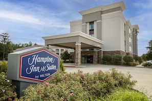 Edificio de un Hampton Inn & Suites by Hilton bajo un cielo despejado.