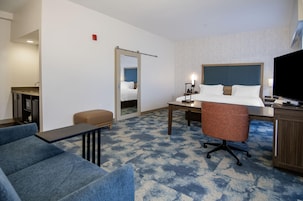 Una habitación de hotel con cama, escritorio, silla y televisión.