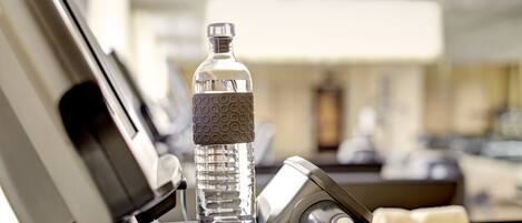 A clear bottle of water on a tray in a hotel setting.