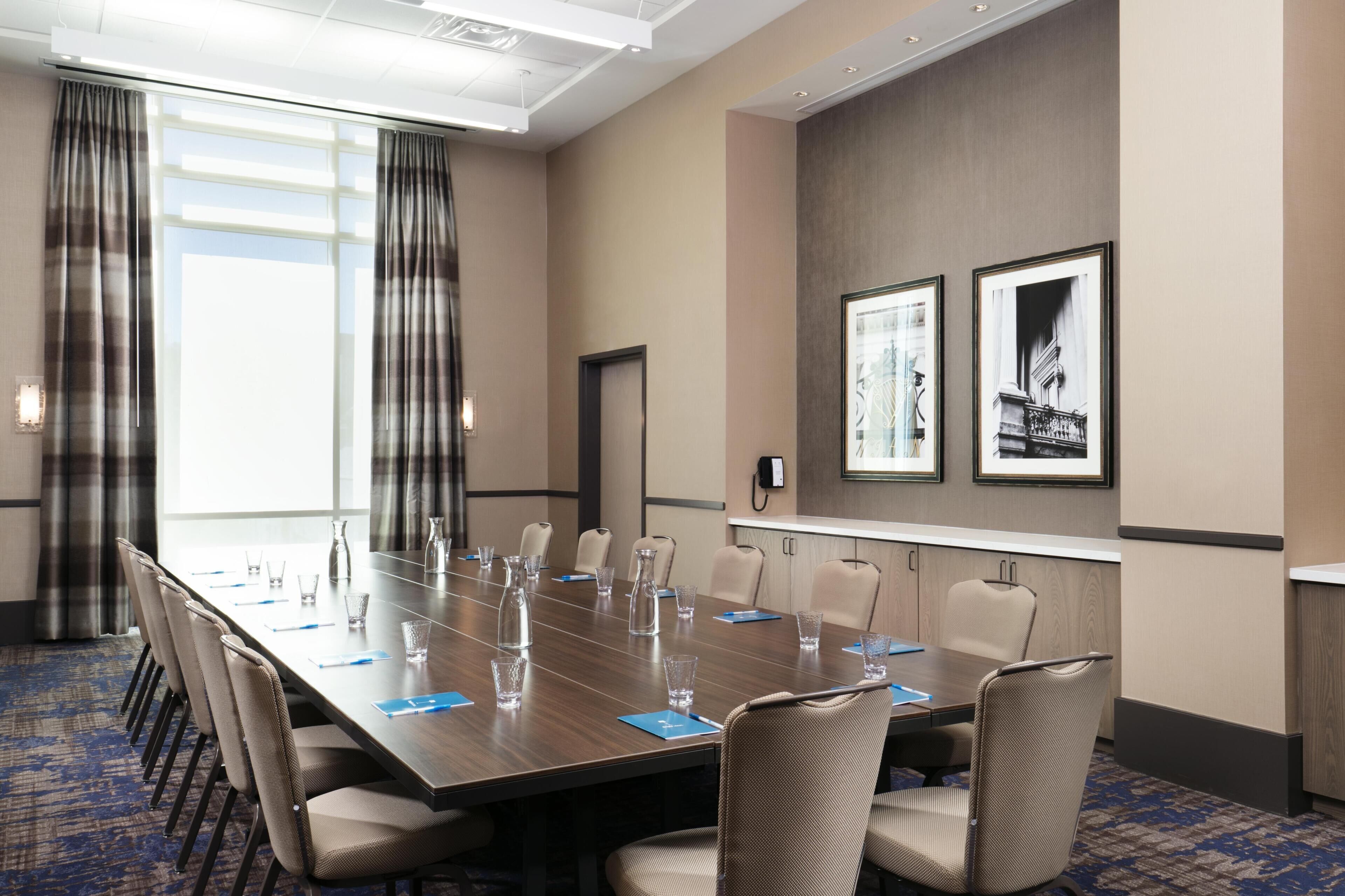 A conference room with a long table, chairs, and a door.