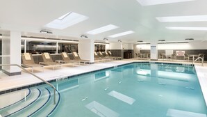 A modern indoor swimming pool with clear water, sunroof lighting, and lounge chairs along the poolside. - Hyatt House Charleston/Historic District (Charleston)