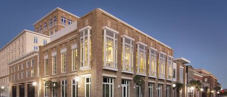 A multi-story hotel with a brick facade, large windows, and a red brick ground floor.