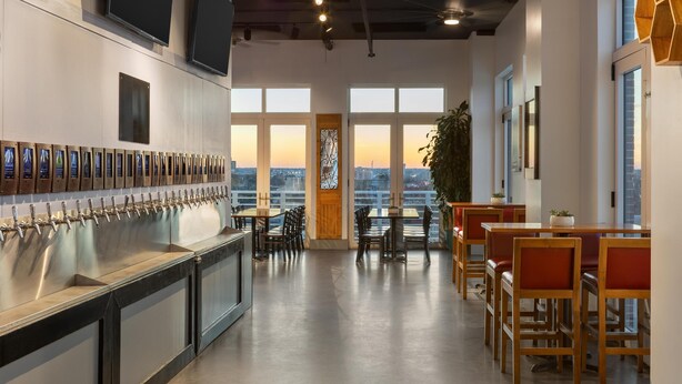 A modern bar area with multiple taps, a long counter, and seating arrangements. - Hyatt House Charleston/Historic District (Charleston)