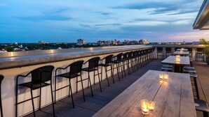 An outdoor seating area with tables and chairs, overlooking a cityscape. - Hyatt House Charleston/Historic District (Charleston)