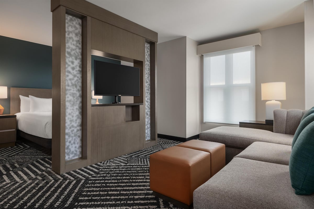 Ett hotellrum med en säng, en tv, en soffa och ett skrivbord.