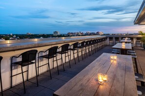 An outdoor seating area with tables and chairs, overlooking a cityscape. - Hyatt House Charleston/Historic District (Charleston)