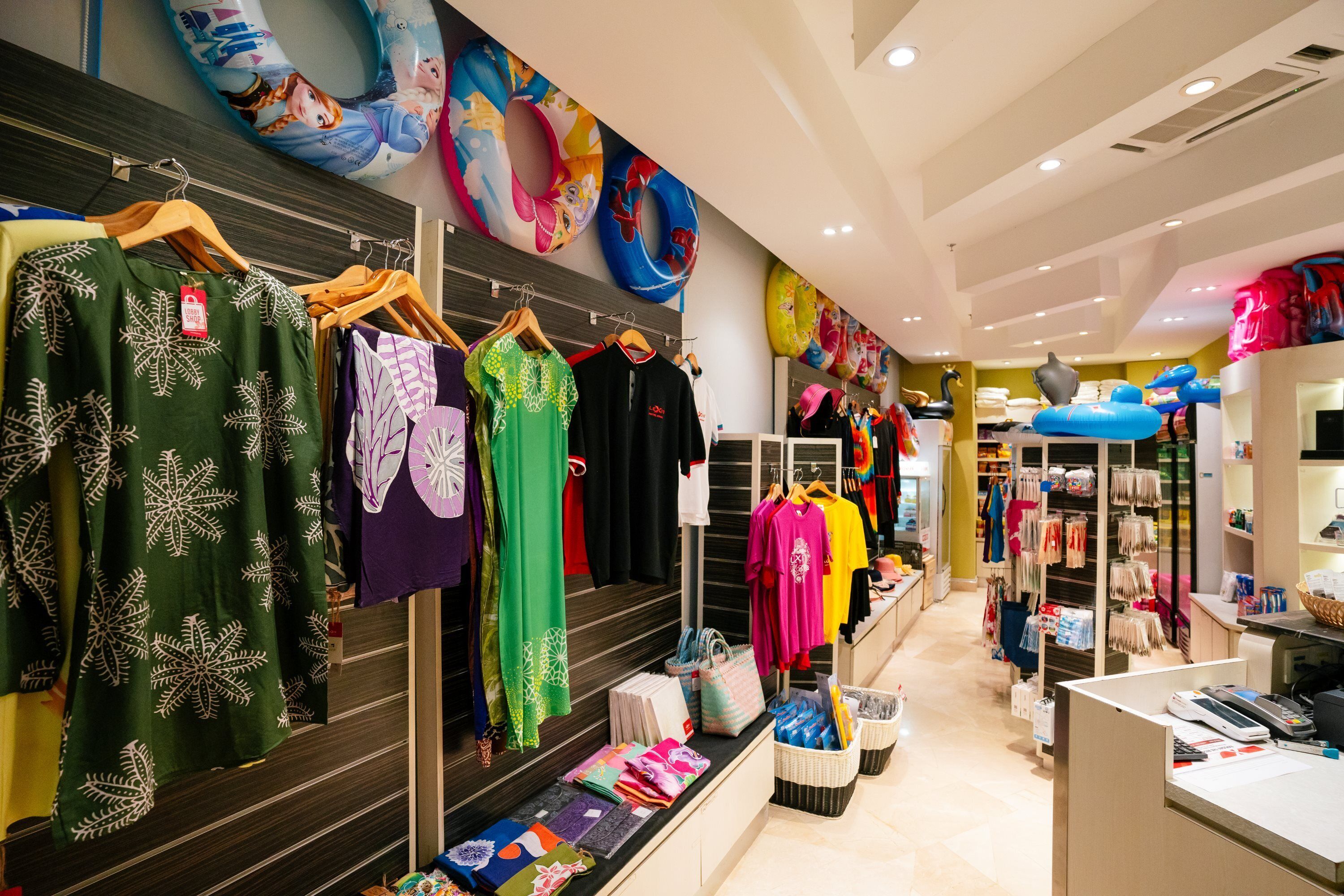 A clothing store with racks of garments and a checkout area.