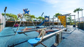 Un parque infantil con columpios, toboganes y estructuras para escalar.