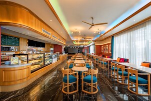 Un hall de hotel con bar, zona de estar y un amplio ventanal.