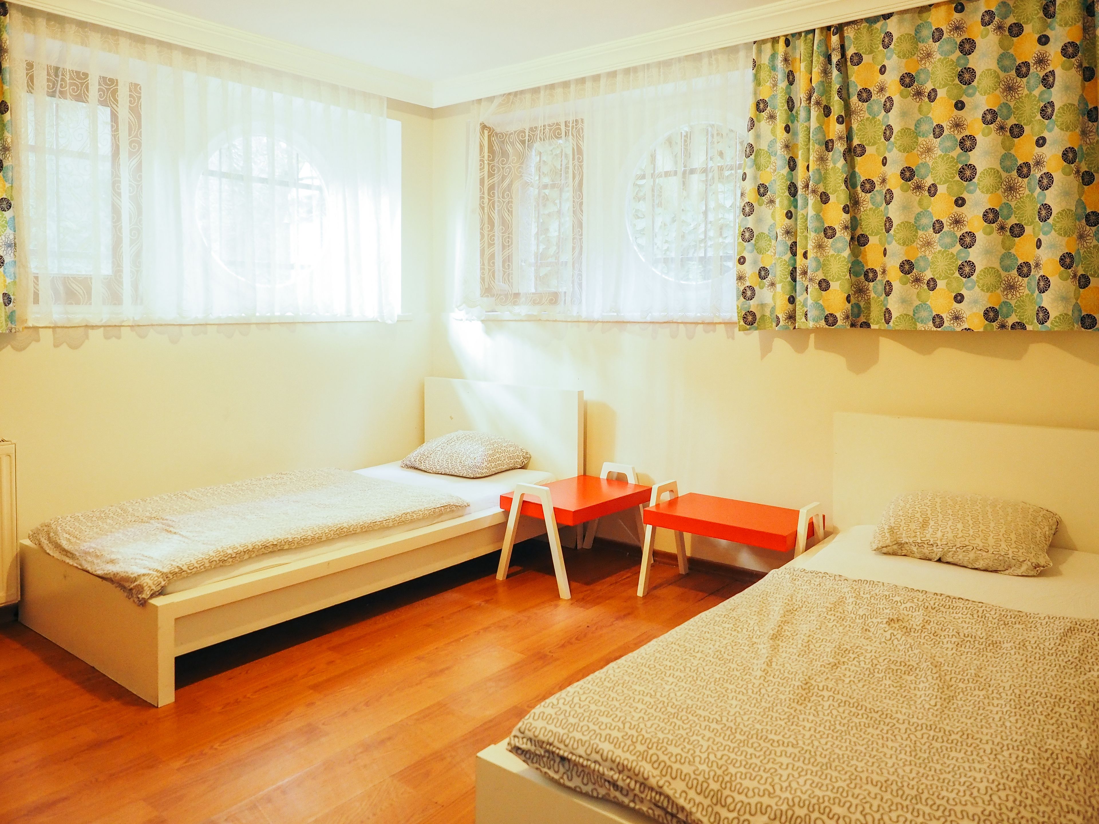 Una habitación con dos camas individuales, una mesita y una silla.