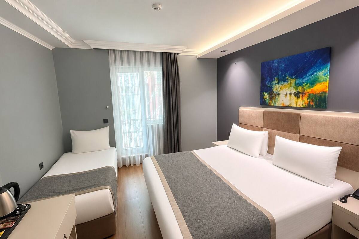 Habitación triple Deluxe | Ropa de cama hipoalergénica, minibar, caja fuerte y escritorio
