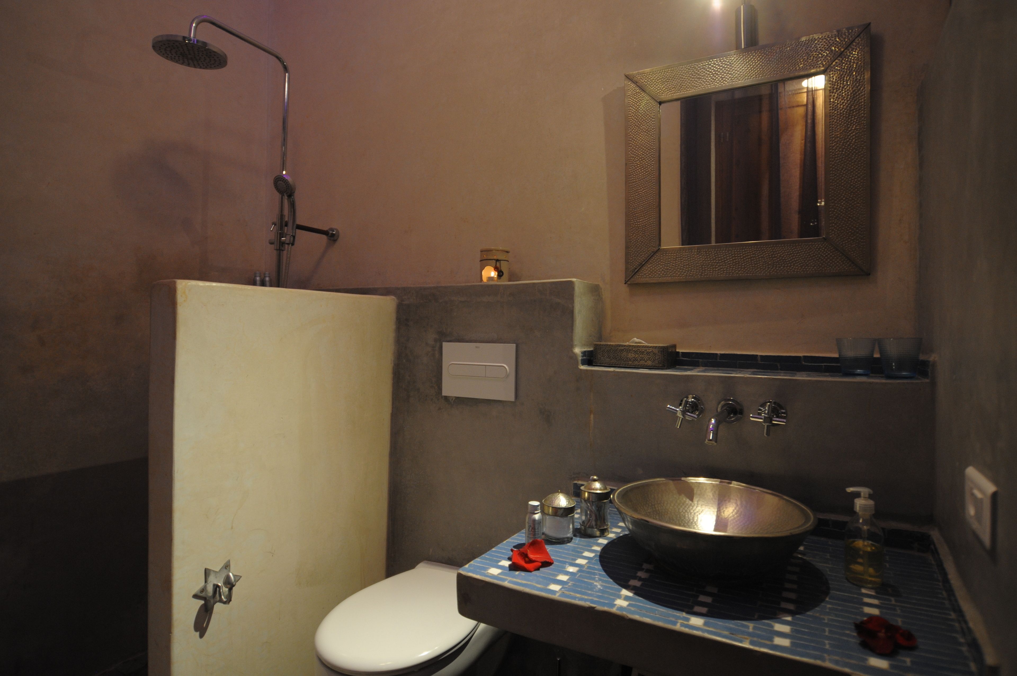Une petite salle de bain comprenant une douche, des toilettes et un lavabo.