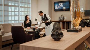 Un hall d’hôtel moderne avec un comptoir d’accueil, un canapé et un téléviseur fixé au mur.