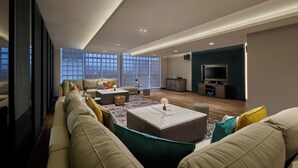 A modern living room with a large sofa, a coffee table, and a television.