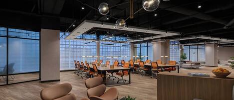 A modern office space with a large conference table, multiple chairs, and a reception area.