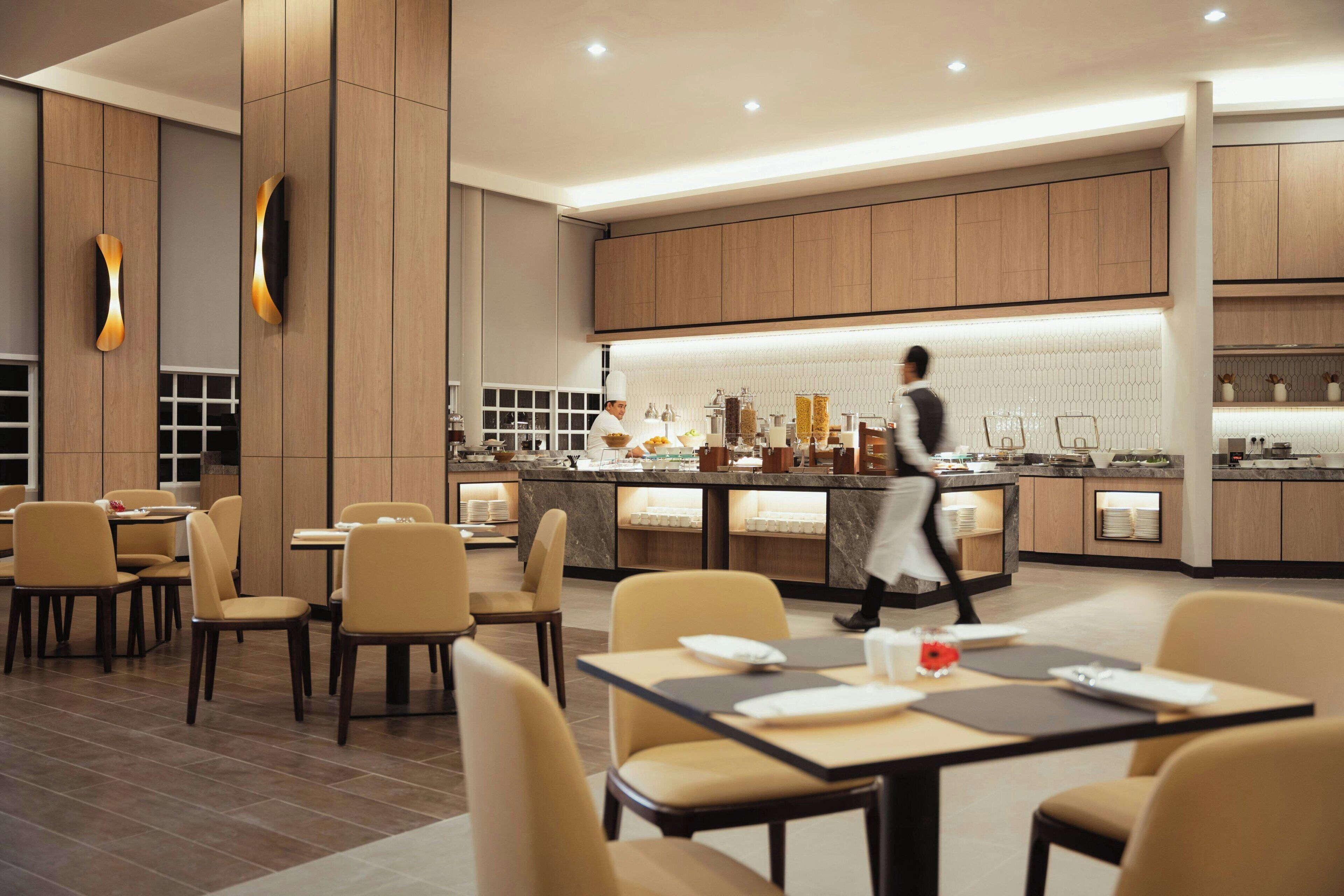 A modern restaurant with a central counter and seating area.