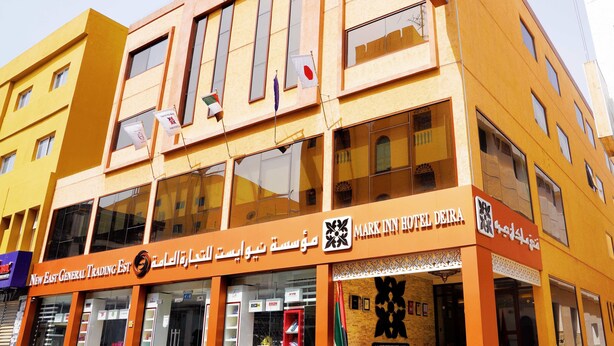 A hotel with a prominent sign for Mark Inn Hotel Deira, featuring a modern design with large windows and a yellow facade. - Mark Inn Hotel Deira (Dubai)