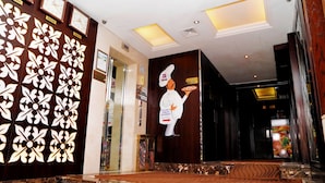 A lobby with a decorative wall, a clock, and a welcome sign. - Mark Inn Hotel Deira (Dubai)