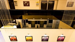 A hotel lobby with a glass partition, multiple doors, and framed artwork on the walls. - Golden Roof Hotel Ampang Ipoh (Ipoh)