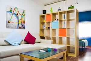 A modern living room with a sofa, a coffee table, and a bookshelf.