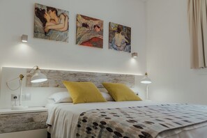 Una camera da letto moderna con una testiera in legno, due abat-jour e un letto con copripiumino fantasia.