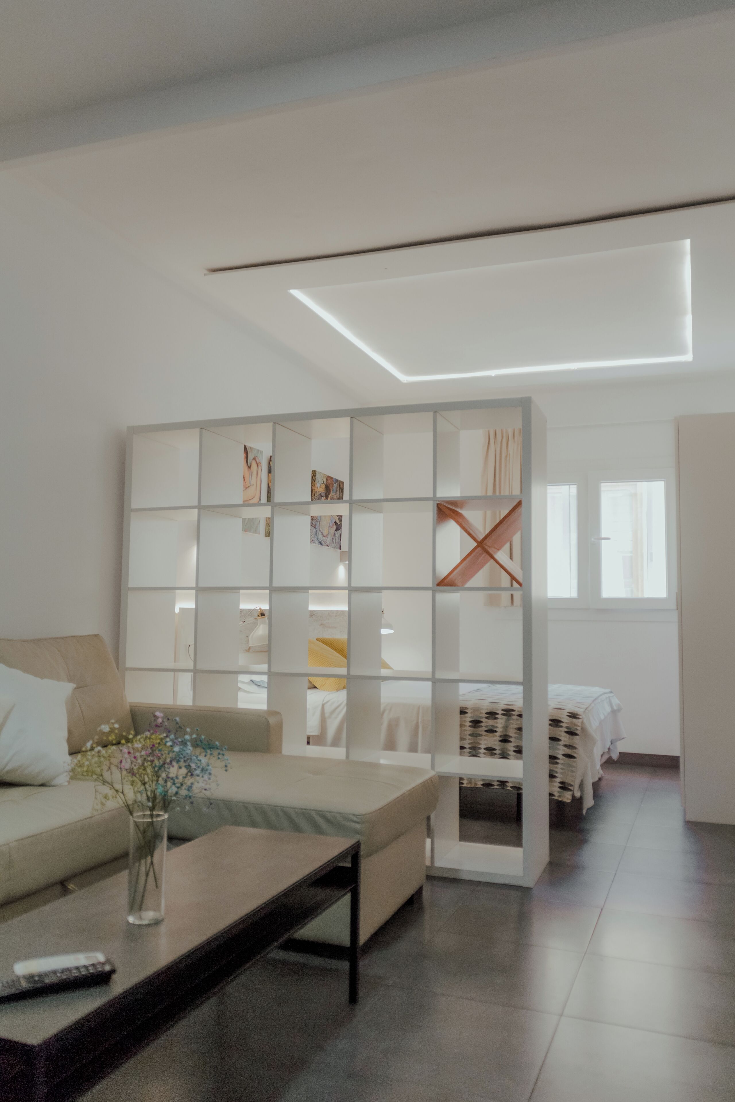 Una sala moderna con un sofá, una mesa de centro y un jarrón decorativo.