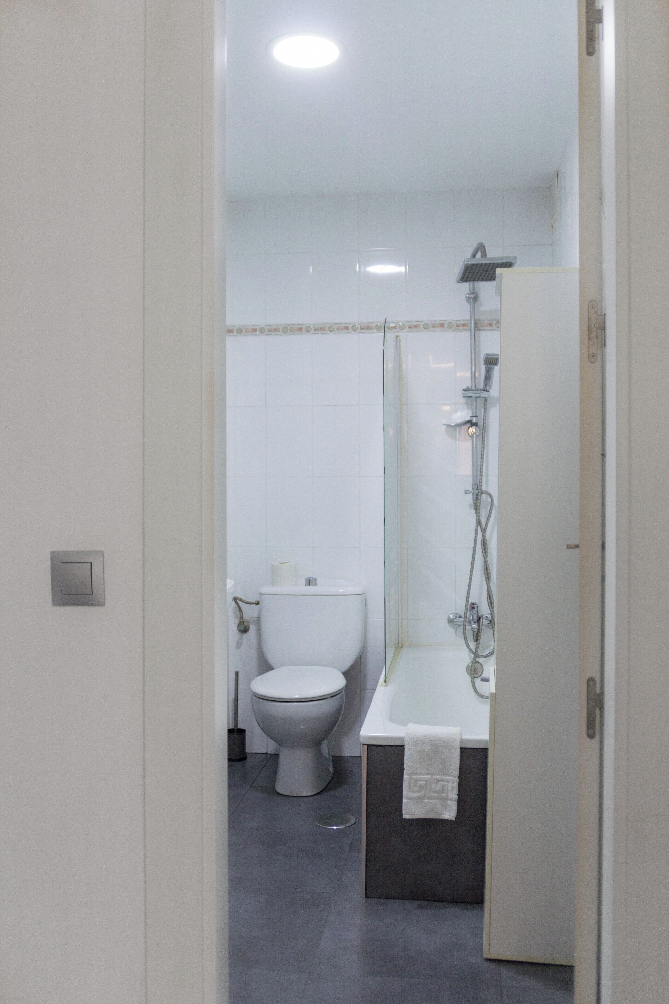 A modern bathroom with a toilet, shower, and bathtub.