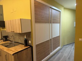 A modern kitchen with a wooden countertop, a sink, and a coffee maker.