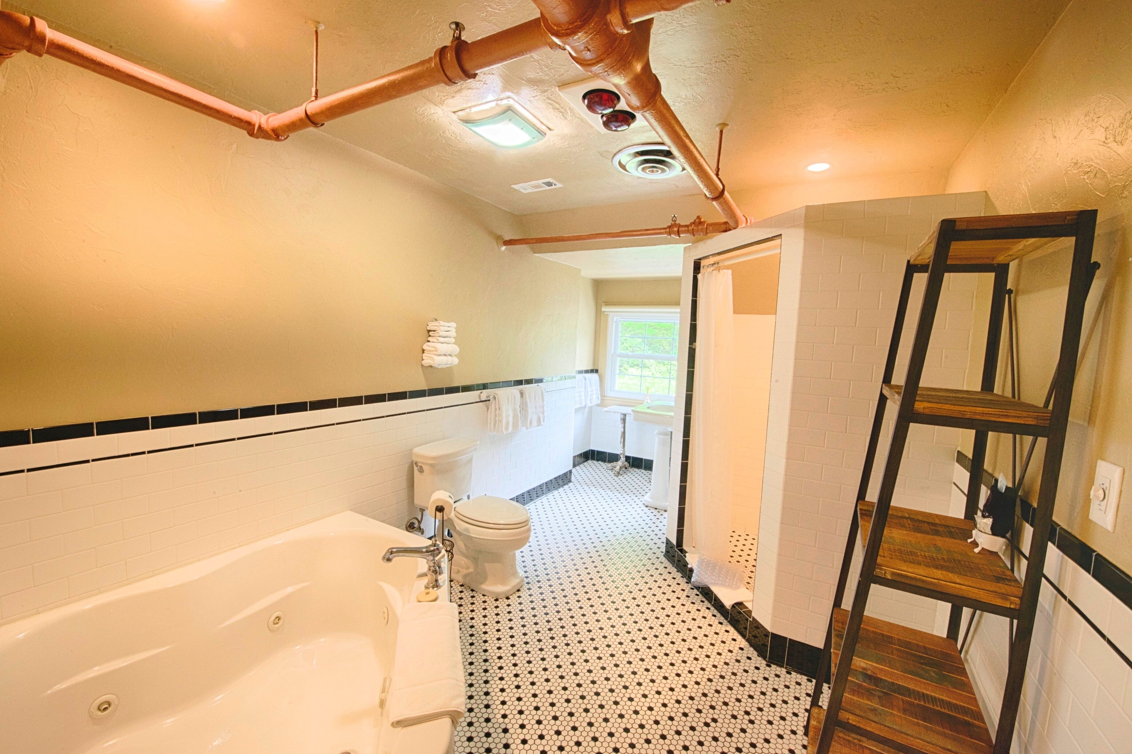 Une salle de bain avec une baignoire, des toilettes et une étagère en bois.
