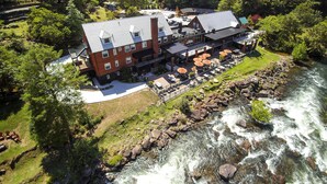 A riverside hotel with outdoor seating and a view of the river. - Historic Tapoco Lodge Resort (Robbinsville)