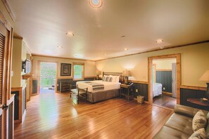 A spacious bedroom with a large bed, bedside tables, and a view of a balcony. - Historic Tapoco Lodge Resort (Robbinsville)