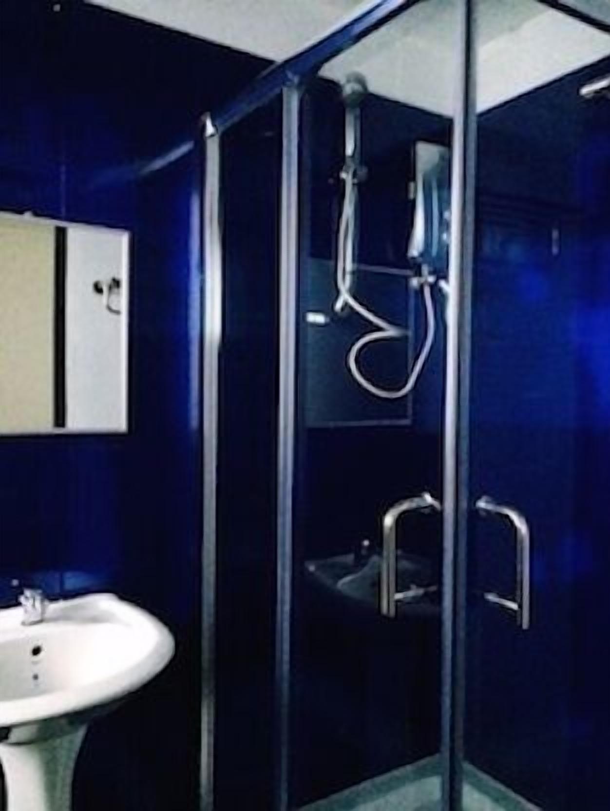 Un baño con ducha de vidrio, lavabo y espejo.