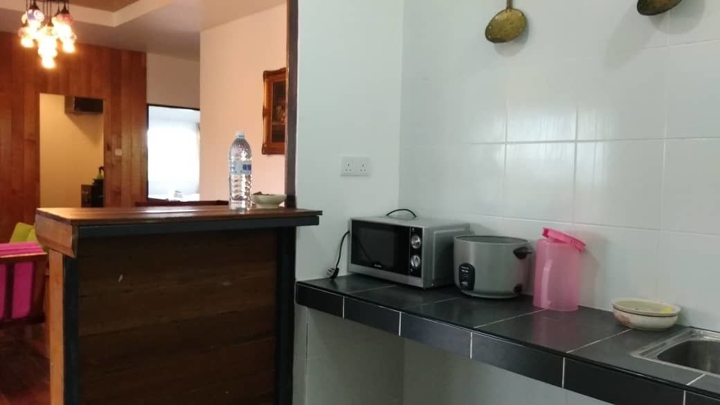 A kitchen with a wooden countertop, a microwave, a toaster, and a sink.