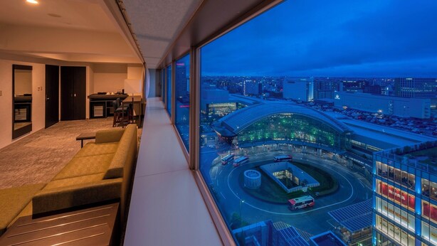 A modern hotel room with a large window overlooking a cityscape and a roundabout.