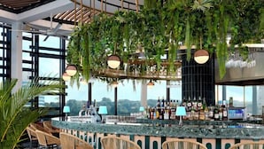 Zona de bar con techo curvo, plantas colgantes y suelo con diseño.