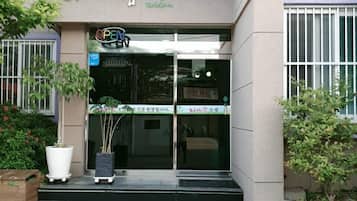 Welcome to our hotel, featuring a modern entrance with a glass door and steps leading up to the entrance.