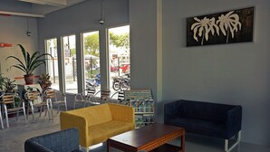 En lobby med siddepladser, et sofabord og en reol.