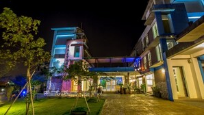A modern hotel with a well-lit entrance, a covered outdoor area, and a landscaped garden. - Vanilla Sky (Wujie)