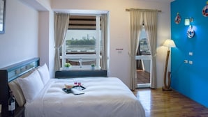 A hotel room with a bed, a window with curtains, a balcony, and a blue wall with decorative plates. - Vanilla Sky (Wujie)
